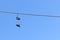 Low angle shot of a pair of shoes hanging from a cable with the breathtaking blue sky in background