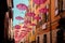 Low angle shot of pink umbrellas hanging above a street of a Grasse in France