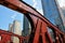 Low angle shot of a red iron bridge and high-rise buildings Chicago