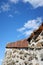 Low angle shot of the side of an old concrete building with a rusty rooftop under a beautiful sky