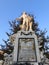 Low angle shot of a statue of Mozart in Austria behind a tree under a blue sky