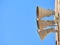 Low angle shot of three loudspeakers attached on a wall against a clear sky