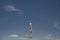 Low angle shot of two radio towers on a blue sky background