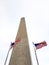 Low angle shot of US flags near a tower, Washington Monument, Washington, D.C., United States