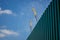 Low-angle shot of a wall with construction cranes in the background