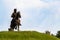 Low angle shot of Warrior Bhai Baaj Singh statue sitting on horse with sword against cloudy sky in the background. historical