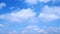 Low-angle shot of white clouds flowing in the blue sky, time-lapse