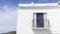 Low angle shot of a white house with a balcony and blue shutters