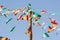 Low angle shot of a wooden pole with small flags of Spain and Andalusia under a clear blue sky