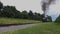 Low Angle of a Steam Passenger Train Starting Up With Puffs of Smoke and Steam