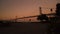 Low angle sunset timelapse, boardwalk San Francisco bay, silhouetted Bay Bridge