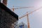 Low angle of two cranes in a construction site under a clear sky background