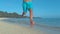 LOW ANGLE: Unknown male tourist goes jogging along breathtaking tropical beach.