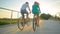 LOW ANGLE: Unrecognizable couple riding their bikes across an overpass at sunset
