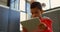 Low angle view of attentive Asian schoolboy studying with digital tablet in classroom at school 4k