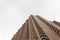 Low Angle view of a brick corner geometrical building with blue cloudy sky