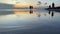 Low angle view of brilliant sunset at ocean shore. POV of small puppy watching beautiful beach with silhouettes of