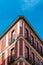 Low angle view of the corner of an old recently renovated residential building against blue sky