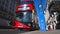 A low angle view of a COVID sign next to the road on a London street with a Red London Double Decker bus driving past