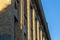 Low angle view of detail of patrimonial yellow brick building facade with decorative pillars and cornice