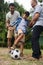 Low angle view of family playing soccer in yard