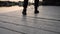 Low angle view of the feet of a man walking on a wooden deck