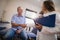 Low angle view of female therapist and senior male patient shaking hands