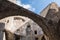 Low angle view of a feudal stone wall castle with blue sky background.