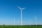 Low angle view of five wind power turbines, part of a wind farm, on a green field in eastern Germany near the city of Cottbus.