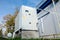 Low angle view of the gray industrial cooling unit standing outdoor on the ground near to the modern of the factory building