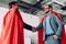 low angle view of handsome super businessmen in masks and capes shaking hands