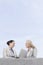 Low angle view of happy young businesswomen with laptop discussing while standing on terrace against sky