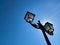 Low angle view on isolated old streetlamp against blue sky with backlight from the sun