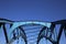 Low angle view on isolated symmetrical industrial steel bridge deck against blue sky with cross struts and metal beams