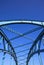 Low angle view on isolated symmetrical industrial steel bridge deck against blue sky with cross struts and metal beams