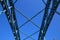 Low angle view on isolated symmetrical industrial steel bridge deck against blue sky with cross struts and metal beams