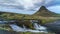 Low angle view of the Kirkjufellsfoss water fall near Grundarfjordur town in Iceland