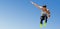 Low angle view of male athlete long jumping against sky