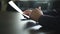 Low angle view of male hand signing contract or subscription form with a pen on a rustic wooden desk