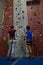 Low angle view of male trainer guiding woman in climbing wall