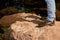 Low angle view of man standing on the rocky cliff