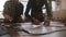 Low angle view of man and woman working together in a manufacture workshop putting cut patterns on big piece of leather.