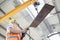 Low angle view of manual worker operating crane lifting sheet metal in industry