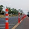 A low-angle view of many reflective orange plastic poles set up as a sign to prevent oncoming traffic