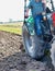 Low angle view of mature farmer standing on tractor in field