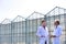 Low angle view of mature male biochemists discussing while standing against clear blue sky