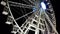 Low angle view of metallic ferris wheel illuminated against night sky