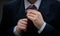 Low angle view of a person fixing his tie dressed in professional attire