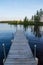 Low angle view of pier jutting out into the Chippewa Flowage in front of a wooded island in the Northwoods forest of Hayward