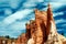 Low angle view on red, orange and white color sedimentary sharp rock tower formation against blue sky